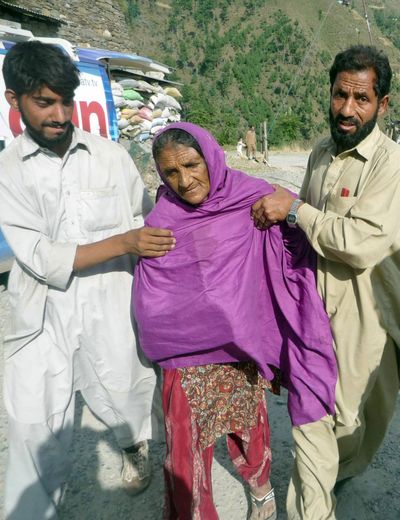 Villagers help an elderly woman after a suicide bombing in Shangla, Pakistan, on Monday.  (Associated Press / The Spokesman-Review)