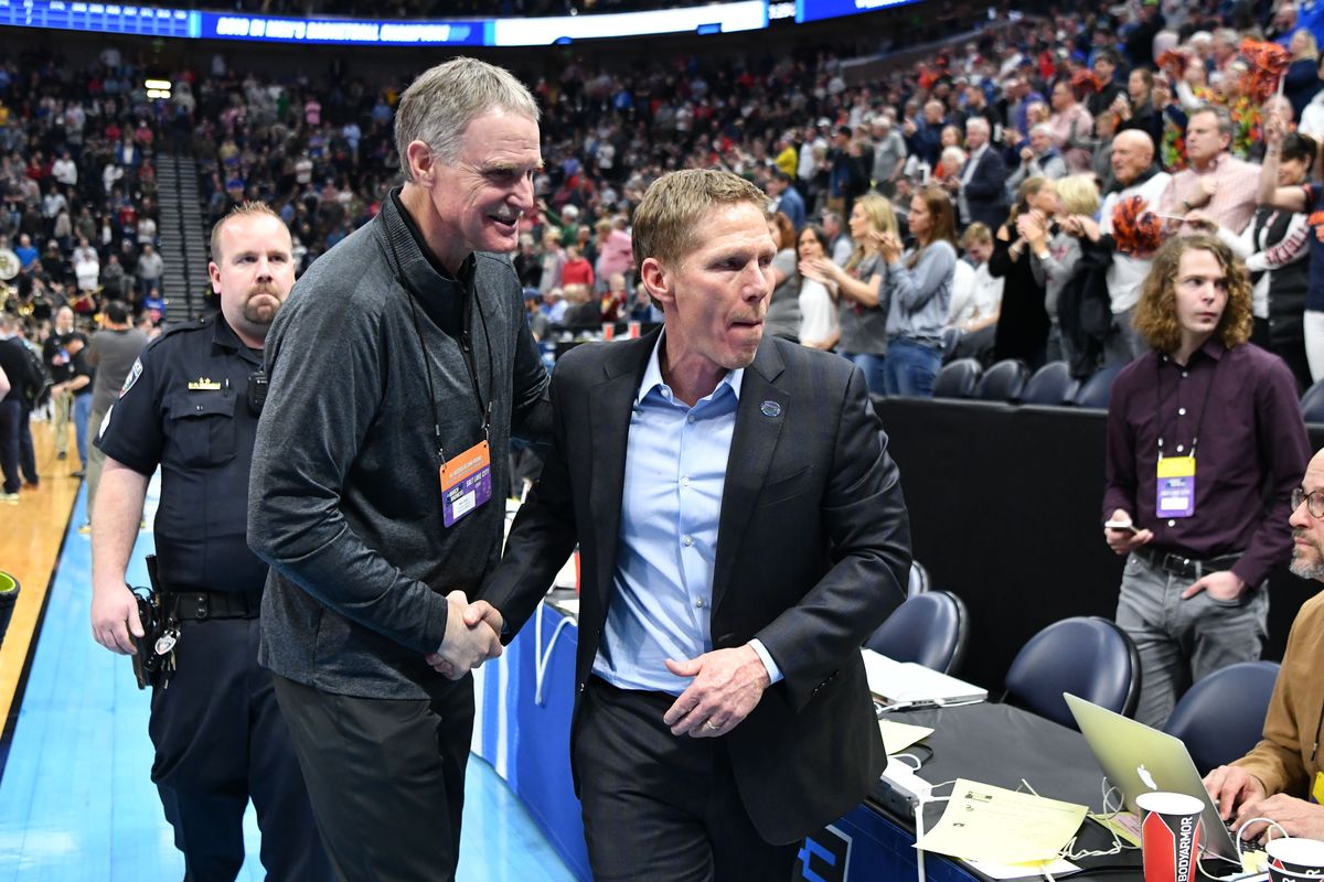 In this March 23, 2019 photo, Gonzaga Bulldogs head coach Mark Few shakes hands with Gonzaga Athletic Director Mike Roth after the second half of a second round men
