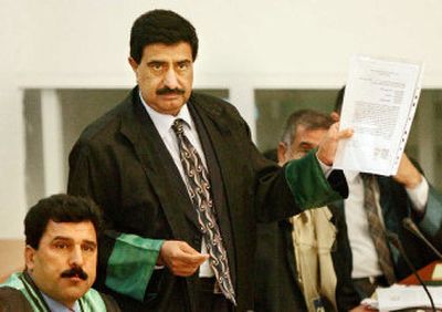 
Khamis al-Obeidi, a lawyer who represented Saddam Hussein, holds up papers during the trial in this October 2005 photo. Al-Obeidi was taken from his home and shot to death Wednesday. 
 (Associated Press / The Spokesman-Review)