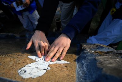 Visitors to Greenwood Memorial Terrace touch the new memorial dedicated to Pfc. Joe E. Mann after a service in his honor last week. (Brian Plonka / The Spokesman-Review)