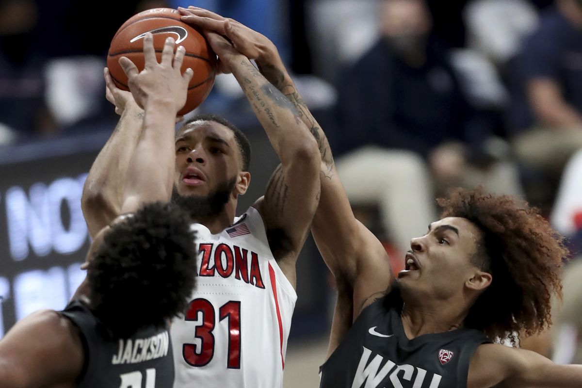Arizona guard Terrell Brown Jr. gets squeezed into a miss by Washington State center Dishon Jackson and guard Isaac Bonton during the first half Thursday in Tucson, Ariz.  (Kelly Presnell/Associated Press)