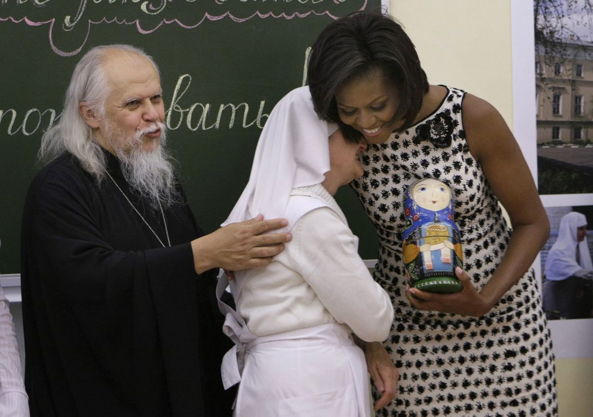 U.S. first lady Michelle Obama hugs Tatyana Filippova, chief sister of the St. Dimitry nurse training college in Moscow, Russia, on Tuesday. Archpriest Arkadiy Shatov, rector of the college, stands at left. (Associated Press / The Spokesman-Review)