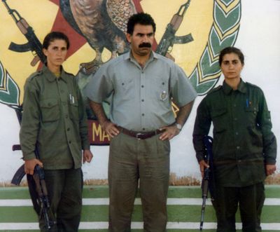 In this early 1990s photo, Sakine Cansiz, left, and another woman surround Abdullah Ocalan, leader of the Kurdistan Workers Party, or PKK, at the Mahzun Korkmaz rebel camp in Lebanon. (Associated Press)