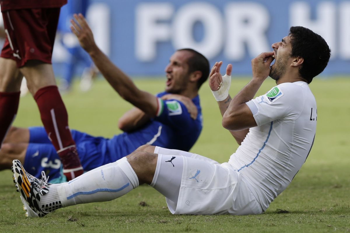 Uruguay’s Luis Suarez, right, and Italy’s Giorgio Chiellini react after Suarez bit Chiellini in a World Cup match. (Associated Press)
