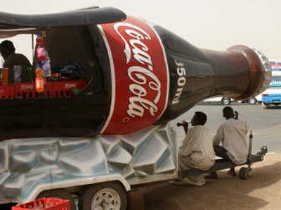 
A Sudanese man drinks Coca-Cola under a bottle-shaped drinks stall in Khartoum last month. The Coca-Cola Co., the world's largest beverage maker, posted a 1 percent profit increase for the second-quarter on a solid 19 percent gain in sales. Associated Press
 (Associated Press / The Spokesman-Review)