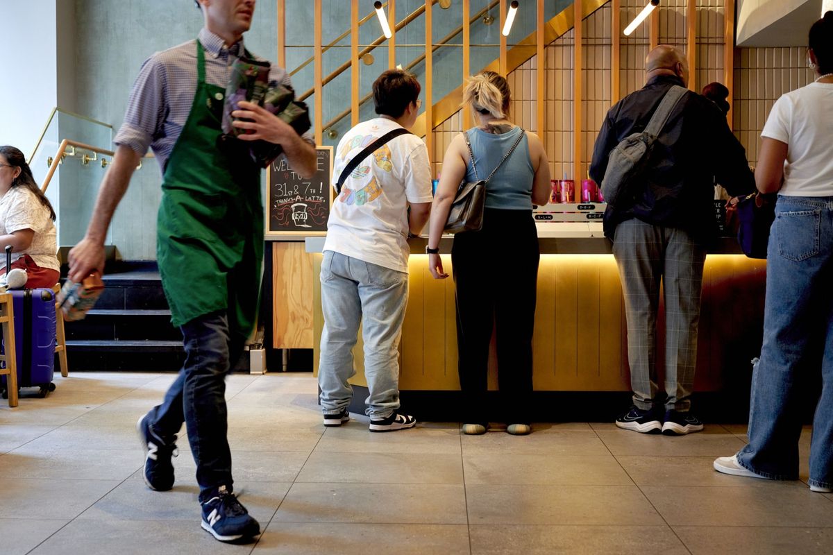 Customers wait to pick up their orders at a Starbucks in New York. Customers have come in droves for their new baked apple croissant.  (Gabby Jones/Bloomberg)