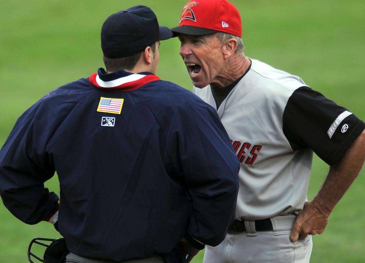 Salem-Keizer manager Tom Trebelhorn argues with umpire Matt Benham after he was thrown out of the game in the third inning.  (Rajah Bose / The Spokesman-Review)