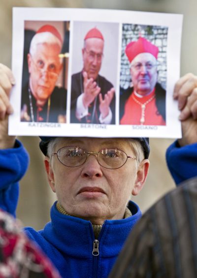 Pamela Meyer holds images  of Catholic leaders  outside the federal courthouse in Milwaukee on Thursday. A lawsuit was filed Thursday that says  the Vatican failed to defrock alleged abusive priest  Lawrence Murphy.  (Associated Press)
