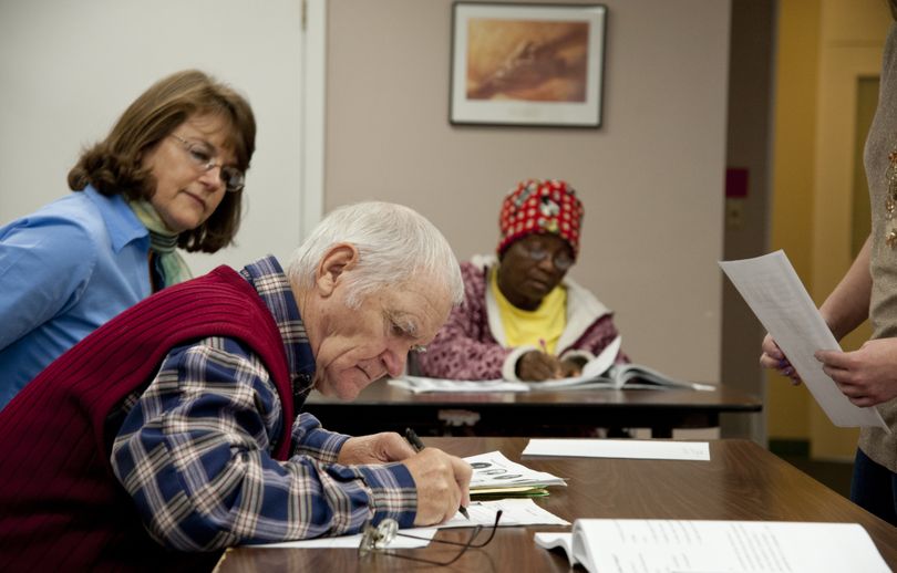 Debbie Johnson, World Relief Spokane Citizenship and Naturalization Program manager, left, works with Veniamin Avdeyev and Ana Mpawanayo, rear, as they take a civics test on Nov. 29 in Spokane. (Dan Pelle)