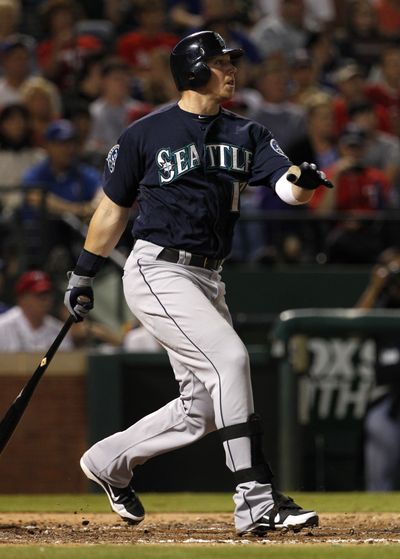Seattle Mariners' Justin Smoak follows through on a single off of Texas Rangers' Scott Feldman, scoring Michael Saunders, in the third inning Saturday. (Tony Gutierrez / Associated Press)