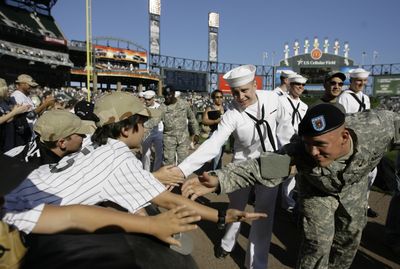 Chicago White Sox fans pay tribute to members of the U.S. Armed Forces before a game as the troops circle the field on the warning track of U.S. Cellular Field  in Chicago on July 4. The White Sox have $1 admission for kids on some Sundays. (Associated Press / The Spokesman-Review)