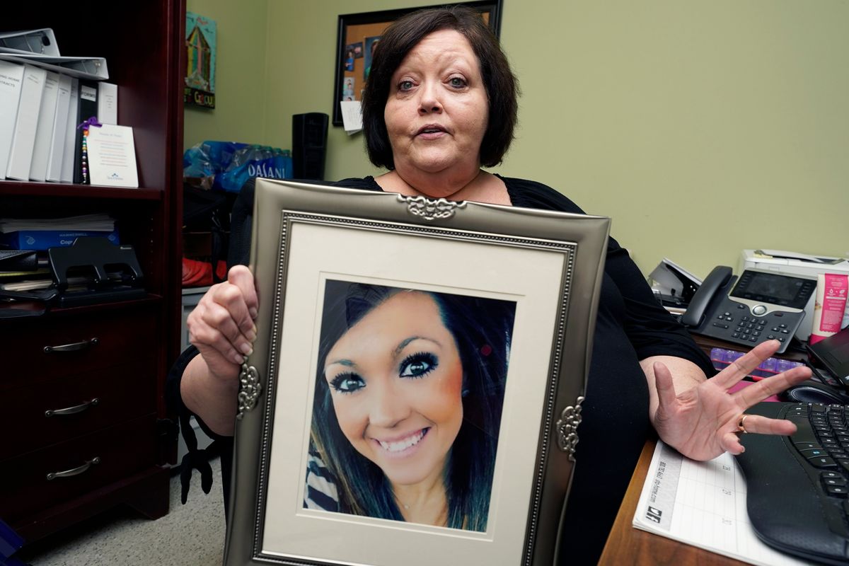 Denise Spears holds a portrait of her late step-daughter, Marsha Harbour, in her Meridian, Miss., office, on April 12. Although Marsha’s husband, Truitt Pace, admitted killing his wife, he was free on bond while court proceedings were partially held up because the Mississippi Medical Examiner’s Office autopsy report was delayed for a year, and the trial got held up further because of the pandemic and other factors. Harbour was a victim of domestic violence.  (Rogelio V. Solis)