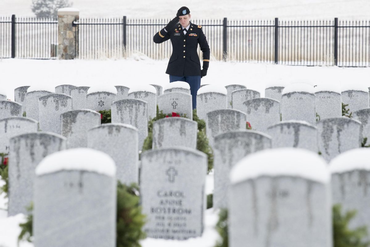 Erin Hagerty, an Army National Guard Transportation Officer salutes the grave of her grandfather, James Hagerty an Army veteran of the Korean War during a Wreaths Across America Ceremony on Saturday, Dec. 16, 2017, at Washington State Veteran