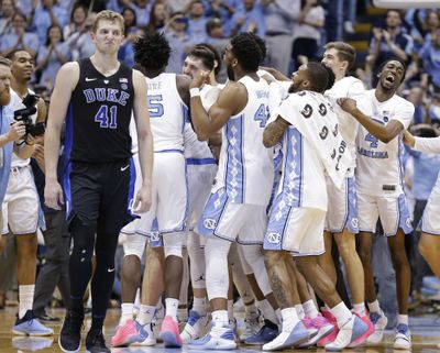 North Carolina players celebrate while Duke's Jack White (41) walks away following an NCAA college basketball game in Chapel Hill, N.C., Saturday, March 9, 2019. North Carolina won 79-70. (Gerry Broome / AP)