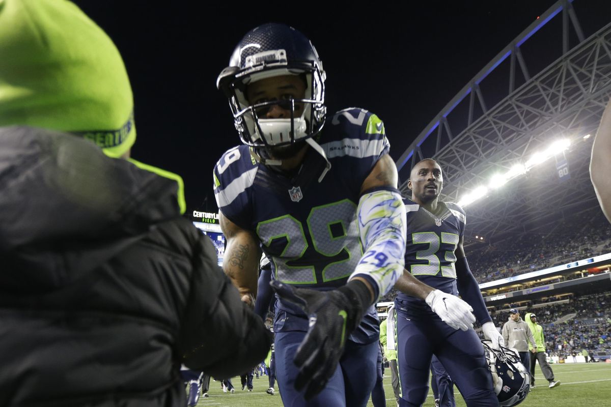 Seattle Seahawks free safety Earl Thomas (29) greets a young fan before an NFL football game against the Carolina Panthers, Sunday, Dec. 4, 2016, in Seattle. (Ted S. Warren / Associated Press)