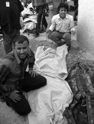 
Iraqis grieve over dead relatives  in Baghdad on Monday. Two nearly simultaneous bombs struck a predominantly Shiite commercial area in central Baghdad. 
 (Associated Press / The Spokesman-Review)