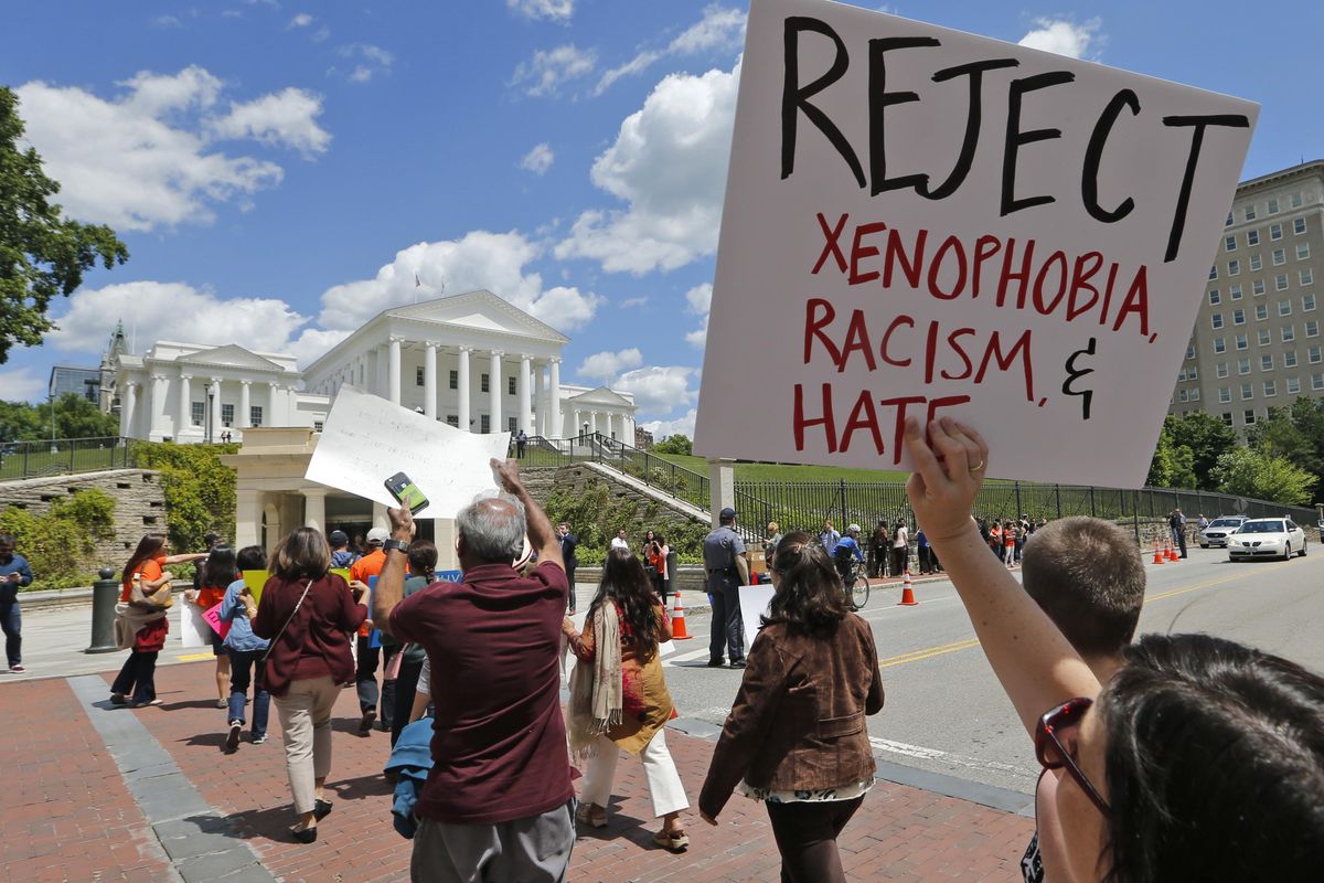 Protesters hold signs and march in front of the State Capitol across the street from the US 4th Circuit Court of Appeals in Richmond, Va., Monday, May 8, 2017. The court will examine a ruling that blocks the administration from temporarily barring new visas for citizens of Iran, Libya, Somalia, Sudan, Syria and Yemen. It’s the first time an appeals court will hear arguments on the revised travel ban, which is likely destined for the U.S. Supreme Court. (Steve Helber / Associated Press)