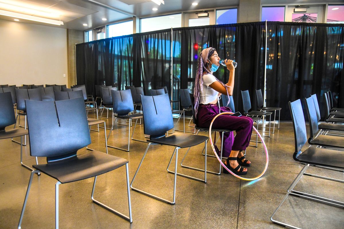 As the temperatures climb into the 90s, “Indigo,” age 24, takes a drink of water while beating the heat in the cooling center located at the Looff Carousel on Saturday in Riverfront Park.  (DAN PELLE/THE SPOKESMAN-REVIEW)