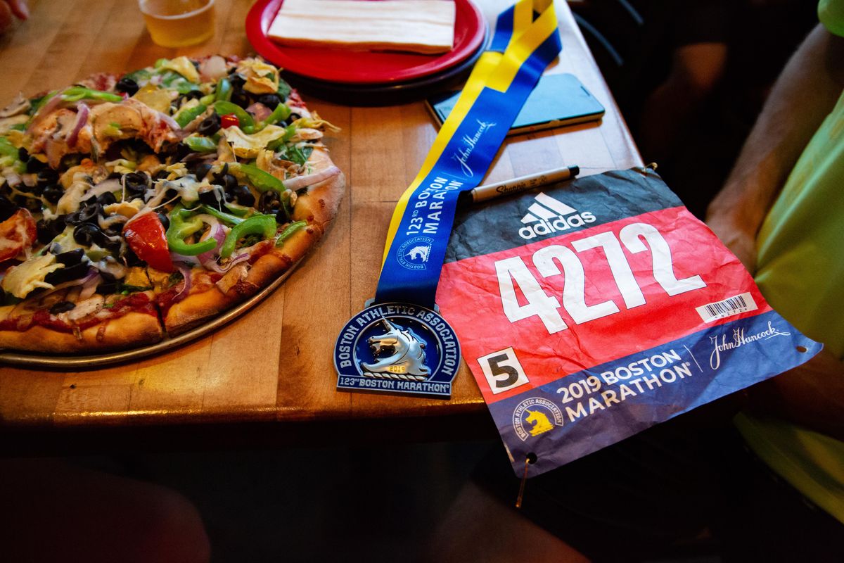Jason Moyer, a member of the Flying Irish Run Club, shows his souvenirs from running in the 2019 Boston Marathon on Monday, after a Thursday run with the club on April 18, 2019. (Libby Kamrowski / The Spokesman-Review)