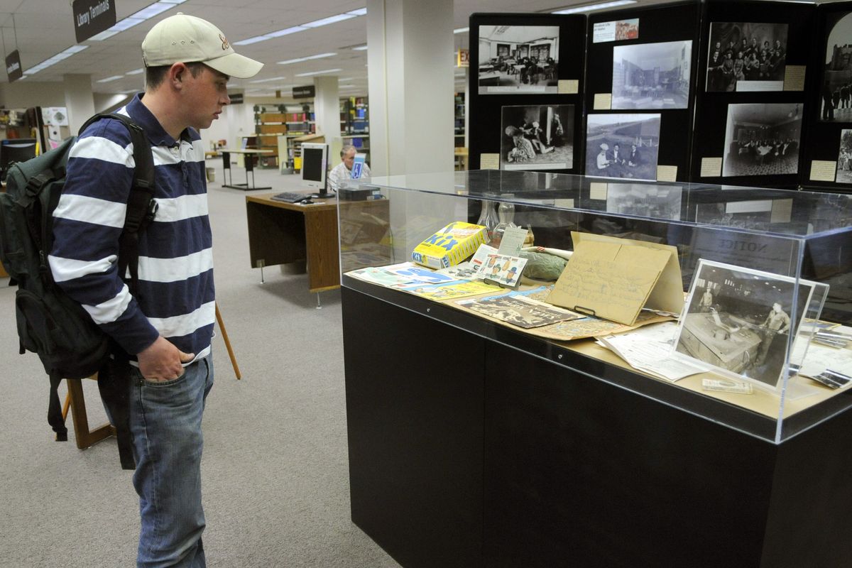 Mechanical engineering student Luke Graham checks out a display in the University of Idaho Library of items found in 55-gallon barrels donated by William C. Cheney  in 1961. The donation came  with instructions not to open the barrels until 2010.  (Colin Mulvany)