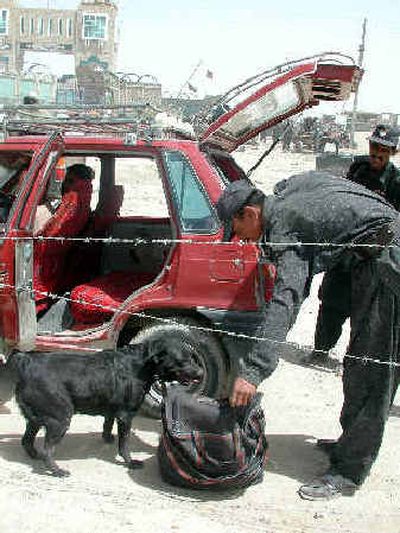 
A Pakistani border guard checks a bag of an Afghan national in Pakistan at the Chaman border post as authorities beefed up security to watch al Qaeda and Taliban movement. 
 (Associated Press / The Spokesman-Review)