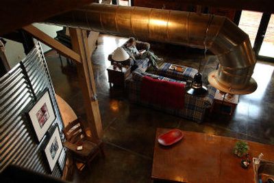 
Susan Hornor relaxes in her 1,700-square-foot condo, accented with a section of a grain silo, in the revitalized Jefferson Auto Building. 
 (The Spokesman-Review)