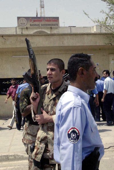 
Iraqi army soldiers and policemen stand guard outside the governor's office in Basra,  Iraq, Wednesday. British troops helped drive off dozens of gunmen who laid siege to the  office. 
 (Associated Press / The Spokesman-Review)