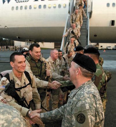 
Soldiers from the 116th Combat Brigade Team are greeted by officers Sunday morning as they step off an airplane at McChord Air Force Base in Tacoma. 
 (Associated Press / The Spokesman-Review)