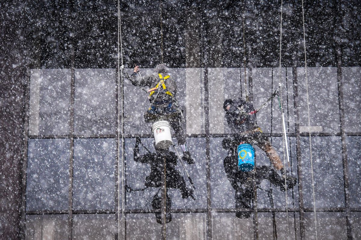 Window washers work through a Friday afternoon snow storm atop the Greater Spokane Incorporated Building, Friday, Nov. 9, 2018. (Dan Pelle / The Spokesman-Review)