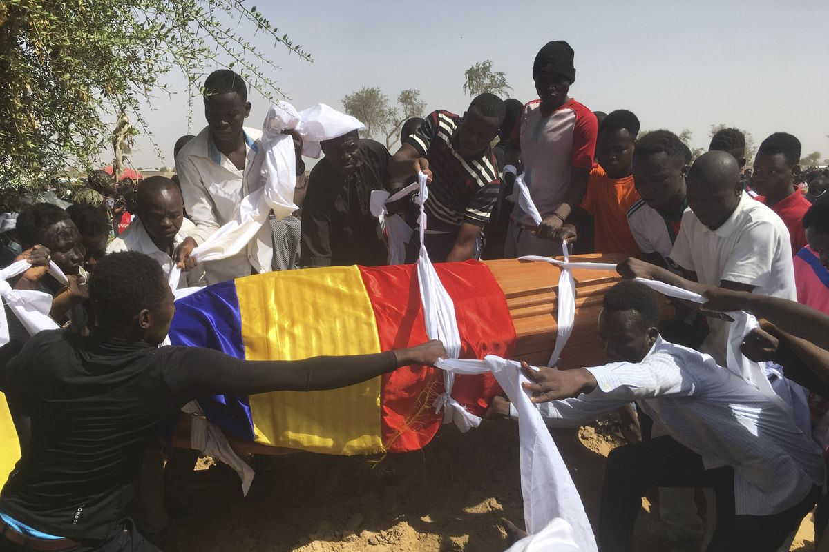 Mourners lower the coffin of one of the victims of protest who was killed this week during his funeral at a cemetery in N