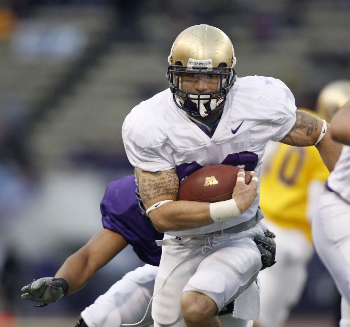 Johri Fogerson carries the ball during Washington’s spring game Friday night at Husky Stadium. (Associated Press)