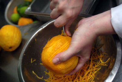 
Becky Wilson of Bonney Lake, Wash., zests 30 oranges for steamed scallops with ginger, basil and orange. 
 (The Spokesman-Review)