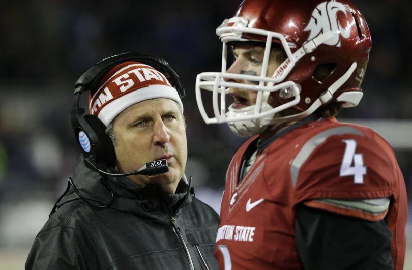 Washington State coach Mike Leach likes the personal approach to getting the ear of his players, as he did here last season with quarterback Luke Falk. (Associated Press)