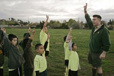 Scoutreach district executive Ramon Loredo Jr., right, leads Boy Scouts in the Scout oath prior to soccer practice  Dec. 16 in San Jose, Calif. The Boy Scouts of America is  trying to draw Hispanics into a declining and mostly white ranks. (Associated Press / The Spokesman-Review)