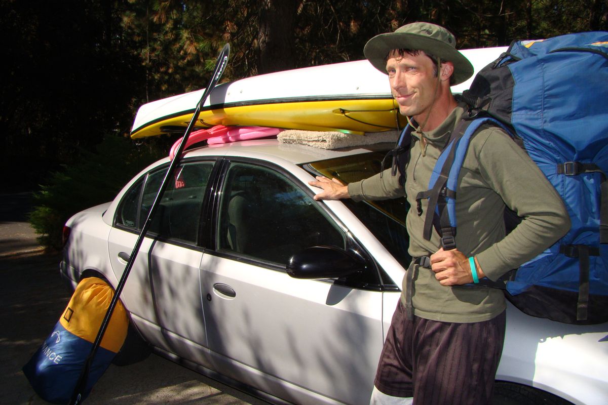 Spokane native John Krauss poses with the paragliding and kayaking gear needed for his combo adventure at Lake Chelan.