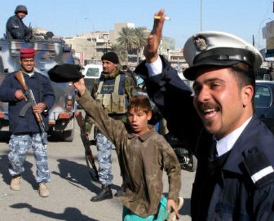
An police officer in Basra, about 340 miles southeast of Baghdad, celebrates Saturday after hearing news of Saddam Hussein's hanging executed.  
 (Associated Press / The Spokesman-Review)
