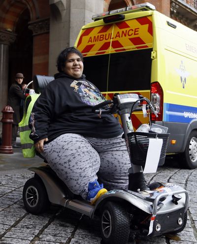 Kevin Chenais sits in his mobility scooter in front of an ambulance at St Pancras in London on Wednesday. (Associated Press)