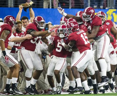 Alabama defensive back Cyrus Jones (5) is mobbed by teammates after intercepting a pass in the end zone during the first half against Michigan State in the Cotton Bowl.