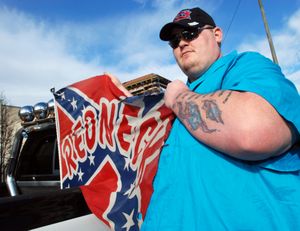 Standing in front of the federal courthouse Thursday, Feb. 9, 2012, in Medford, Ore., Ken Webber shows off the Confederate battle flag emblazoned with the word "Redneck'' that got him fired as a school bus driver. The father of four young children, Webber hopes to get the job back with a lawsuit arguing his First Amendment rights were violated. (Jeff Barnard / Associated Press)