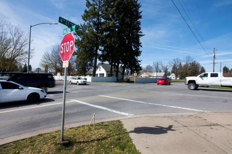 Automobiles drive through the four-way stop intersection of Dalton Avenue and Fourth Street on Wednesday. The City of Dalton Gardens has proposed to install a roundabout at the intersection, as part of the city's Fourth Street reconstruction project. (Jake Parrish/Coeur d'Alene Press)