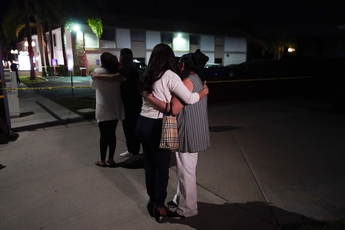 Unidentified people comfort each other as they stand near a business building where a shooting occurred in Orange, Calif., Wednesday, March 31, 2021. Police say several people were killed, including a child, and the suspected shooter was wounded by police.  (Jae C. Hong)