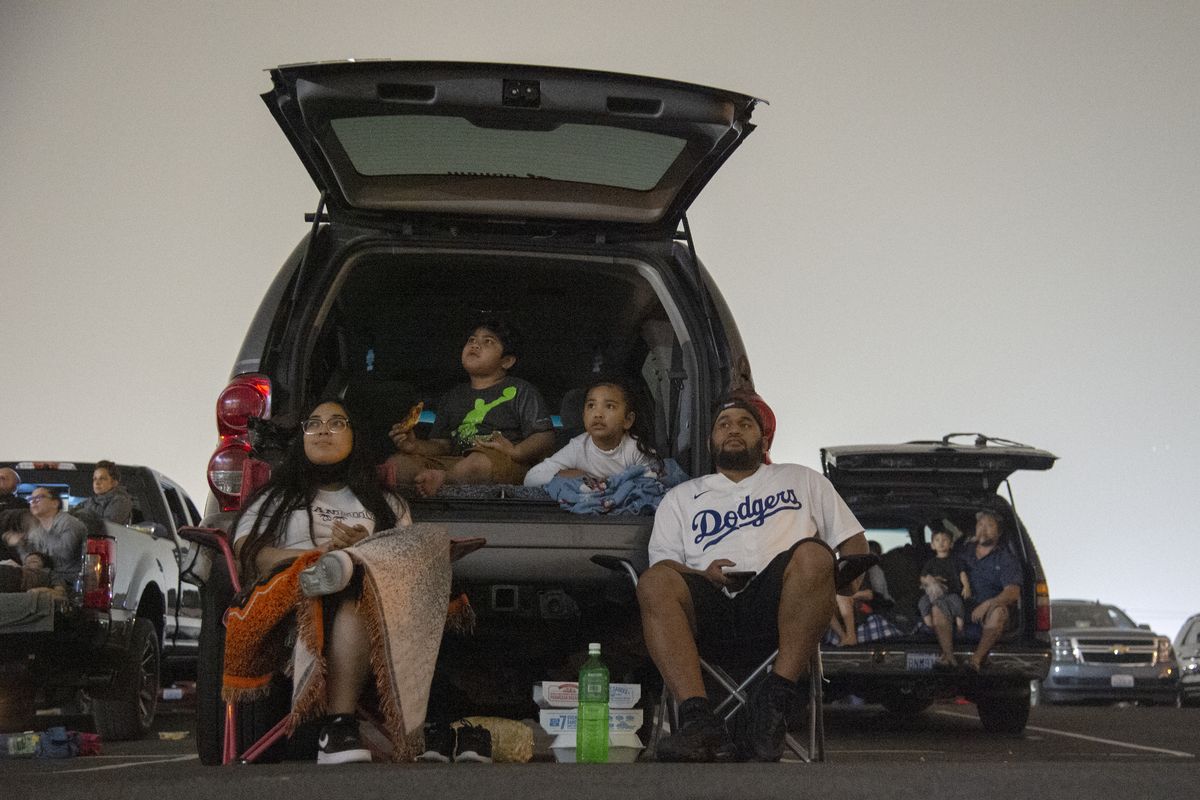 On the first night of the Spokane Drive-In at the Spokane Fair and Expo Center, Mindyrose Olaitiman, Mylove Rudolph, age 6, Clara Aguon, 4, and Franky Lard spill out of the back of an SUV and watch “Sonic the Hedgehog” at the newpop-up movie venue that began operating Friday, Sept. 18, 2020.  (JESSE TINSLEY)