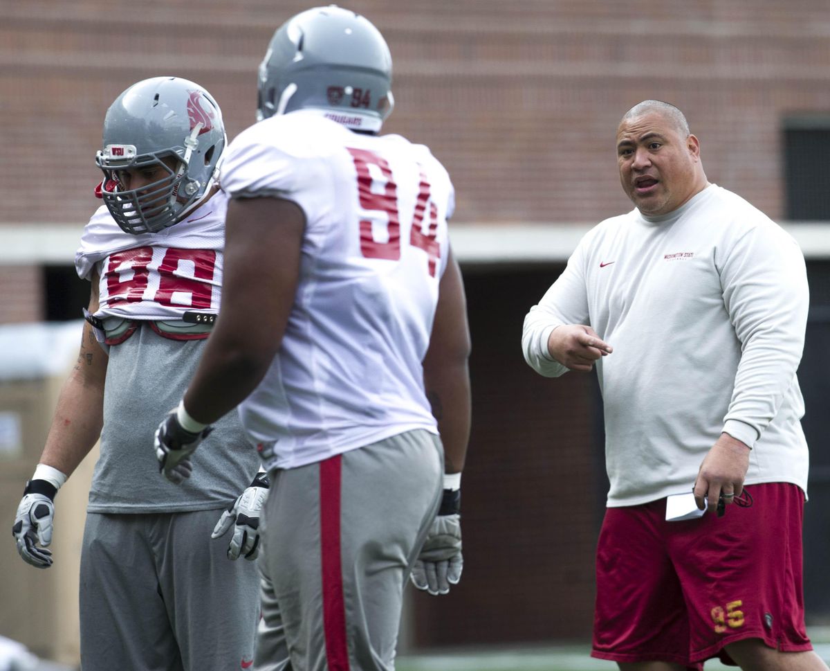 WSU defensive line coach Joe Salave’a gives pointers to his players during practice. (Tyler Tjomsland / The Spokesman-Review)