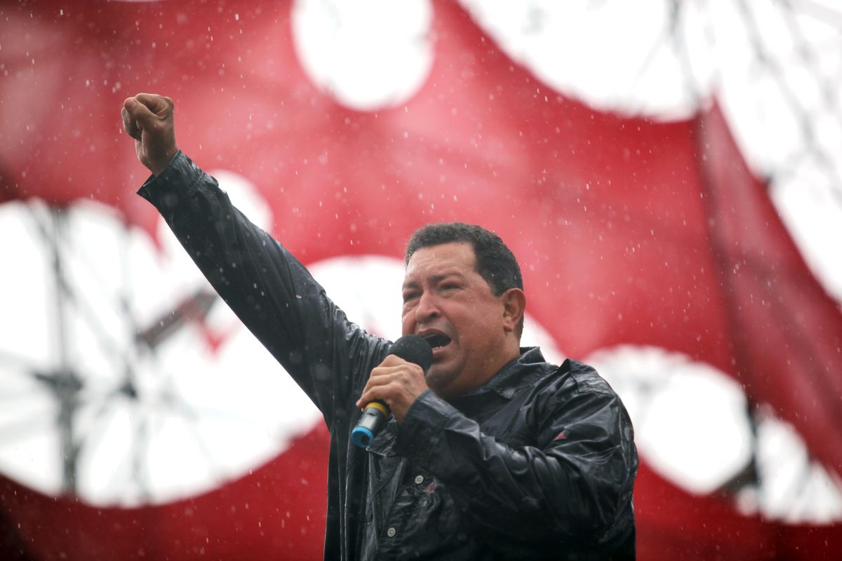 Under a pouring rain, Venezuela’s President Hugo Chavez speaks at a mass rally Thursday in Caracas. (Associated Press)