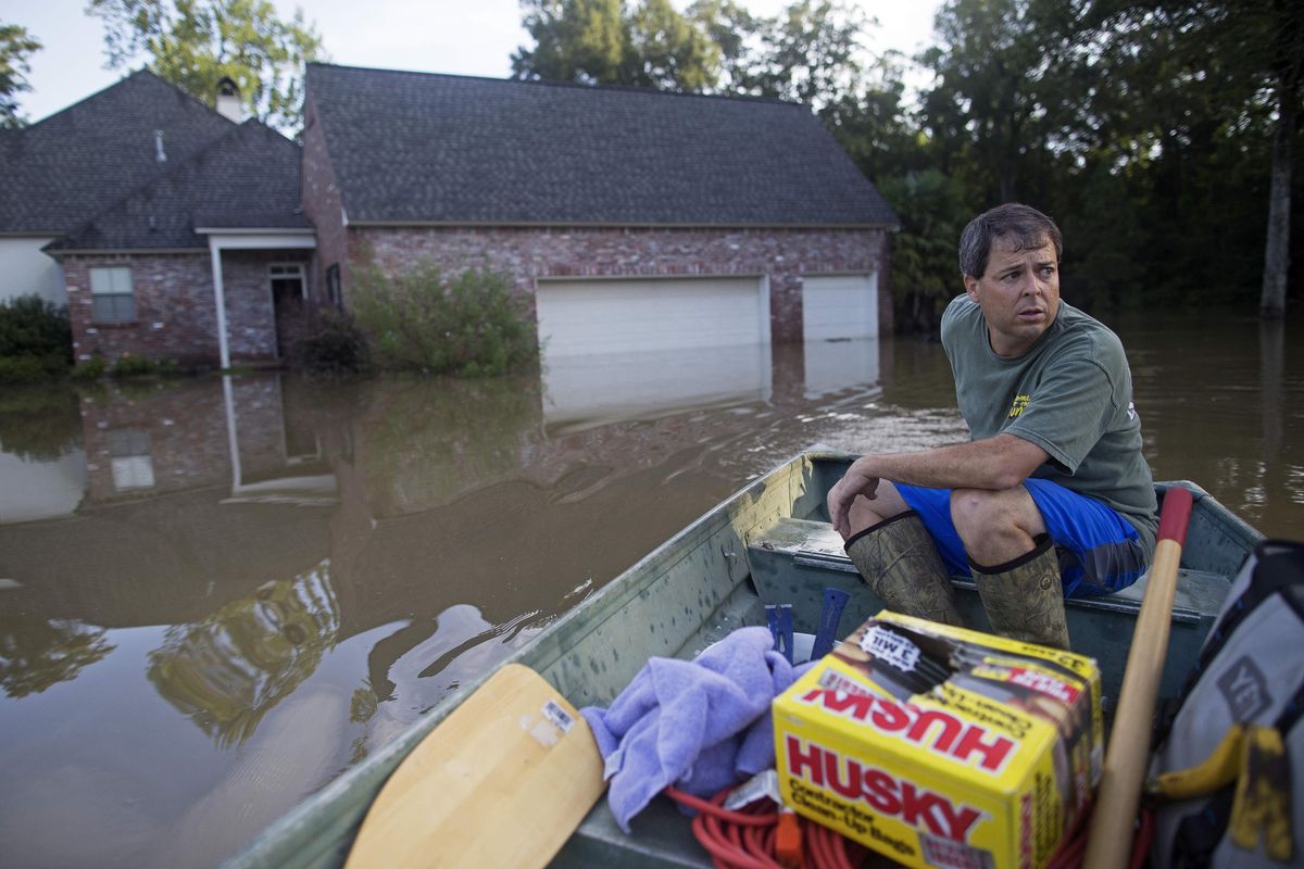 David Key boats away from his flooded home after reviewing the damage in Prairieville, La., Tuesday, Aug. 16, 2016. Key, an insurance adjuster, fled his home as the flood water was rising with his wife and three children and returned Tuesday  to assess the damage. (Max Becherer / Associated Press)