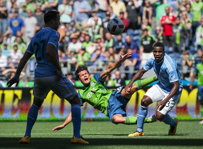Sounders forward Nelson Valdez falls as he collides with New York City FC defender Jefferson Mena in the second half of 2-0 loss. (Associated Press)