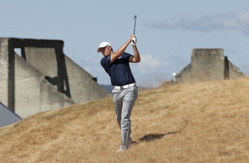 Jordan Spieth hits out of the tall fescue grass on the 18th hole at Chambers Bay on Friday. He took a six on the hole that was set up as a par 4 for the second round. Speith was heard to say of the 18th: “the dumbest hole I’ve played in my life.” (Associated Press)