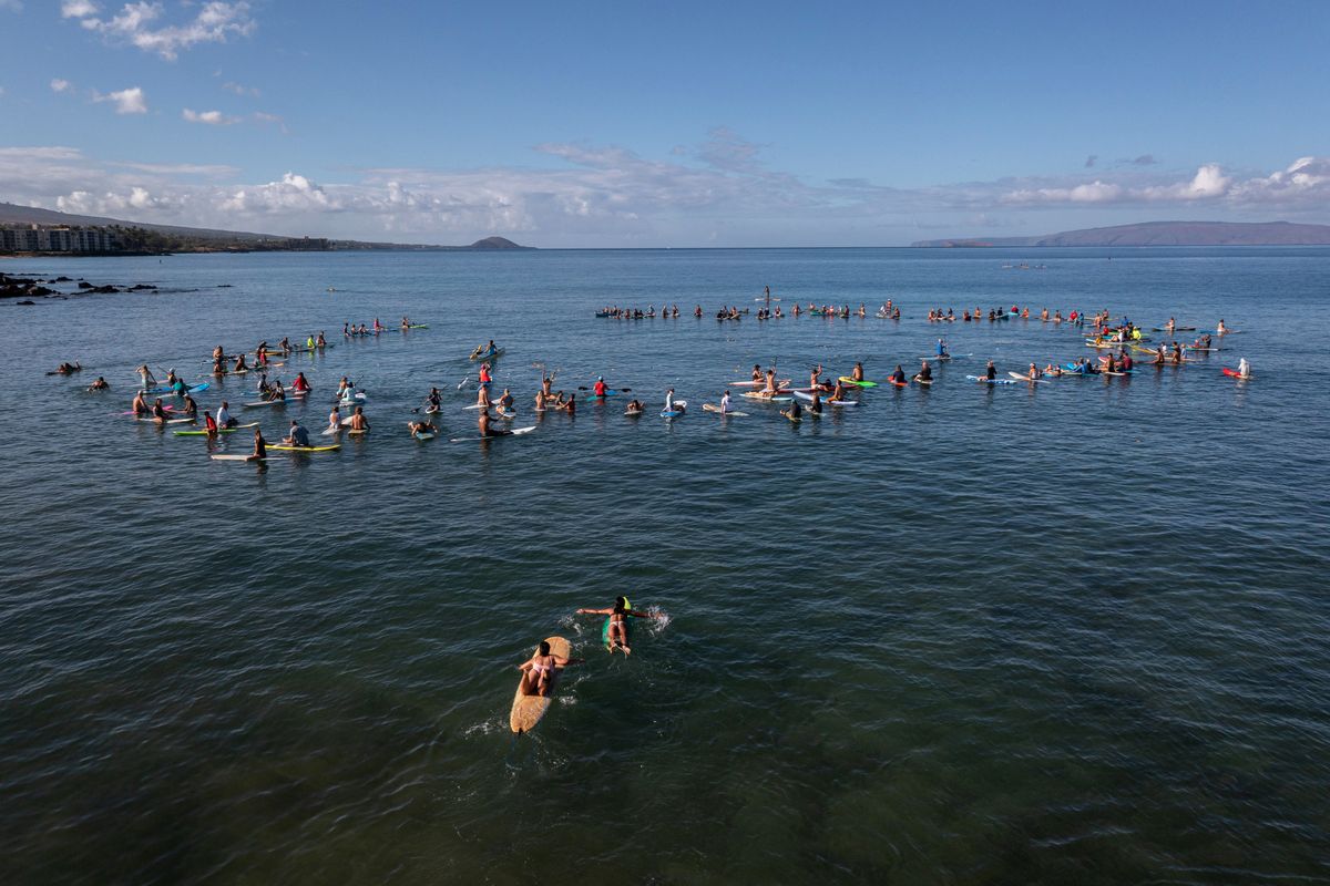 Victoria Gladden and her 14-year-old daughter Brianna swim toward a paddle-out honoring those affected by the Lahaina and Kula wildfires.    (Tamir Kalifa/For The Washington Post)