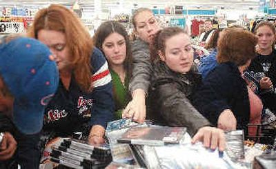 Christmas shoppers reach for DVDs that were on sale last week at Wal-Mart in Emporia, Kan.
(Associated Press / The Spokesman-Review)