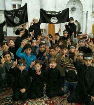 In this undated image posted online and made available Thursday, children pose with Islamic State flags in Raqqa, Syria. (Associated Press)
